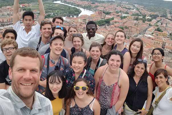 group of students doing a selfie photo overlooking Cagliari island in Italy