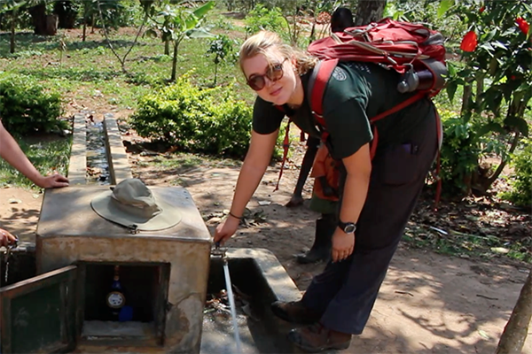 student learning over concrete water system in rural area abroad